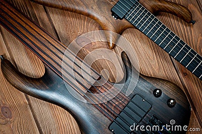 Electric rhythm guitar and five-string bass photographed on a wooden surface Stock Photo