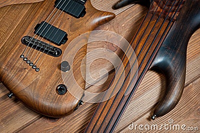 Electric rhythm guitar and five-string bass photographed on a wooden surface Stock Photo