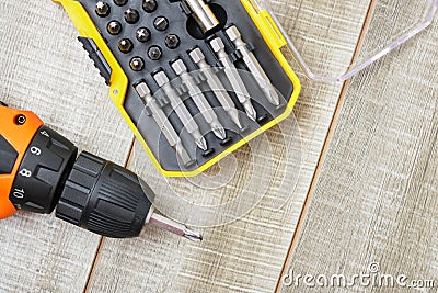 Electric screwdriver, self-tapping screws, screwdriver bits, tool box on a wooden background Stock Photo