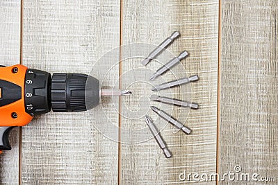 Electric screwdriver, self-tapping screws, screwdriver bits, tool box on a wooden background Stock Photo