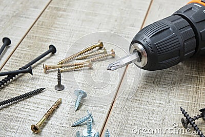 Electric screwdriver, self-tapping screws,, tool box on a wooden background Stock Photo