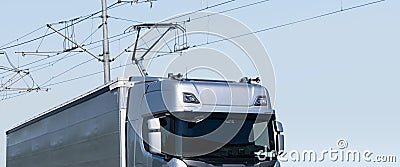 Electric semi truck with pantograph takes energy from wires above the highway Stock Photo