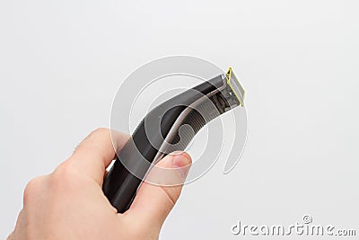 Electric shaving trimmer in hand on white background Stock Photo