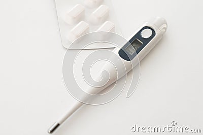 Electric thermometer and pills. Stock Photo