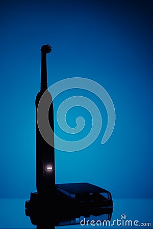 Electric toothbrush silhouette, blue background Stock Photo