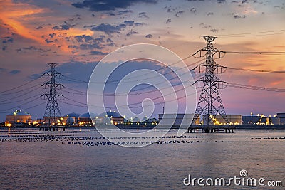 Electric towers and refinary oil storage plant in twilight Stock Photo