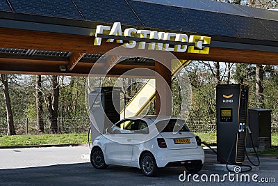 Charging a Fiat 500E with electricity at a public charging station in the Netherlands Editorial Stock Photo