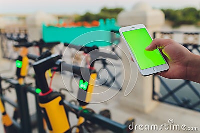 Electric urban transportation: the row of electric readies to ride scooter bikes with accumulators in the center of a Stock Photo