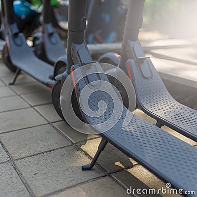 Electric urban transportation: the row of electric readies to ride scooter bikes with accumulators Stock Photo