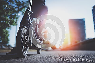 Electric urban transportation.Young man ready to ride his electric scooter bike in the center of a city. Innovative Stock Photo