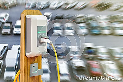Electric vehicle charging Ev station with plug of power cable supply for Ev car on many car blur background Stock Photo