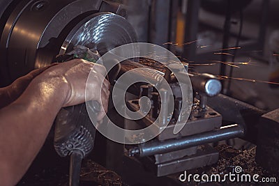Electric wheel grinding on steel structure and welders with multiple sparks in factory Stock Photo