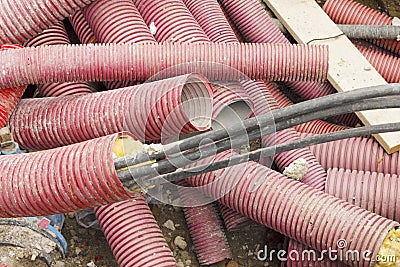 Electric wires in protective tubes. Excavation and maintenance. Stock Photo