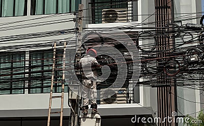 Electric.Working man repairs an electrical malfunction in the wiring. Thailand Bangkok Editorial Stock Photo