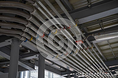 Electrical conduit system and tube of electric cable installed on building ceiling. Industrial infrastructure. Efficient Stock Photo