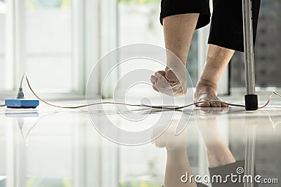 Electrical cord or socket cluttered on the floor,feet of senior woman stepping over obstacles,elderly people walking with Stock Photo