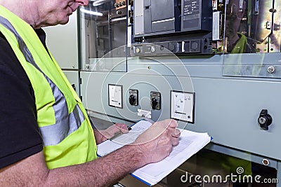 Electrical engineer in hi viz vest inspecting some circuit brteakers Stock Photo