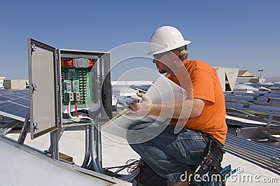 Electrical Engineer Holding Book While Analyzing Electricity Box Stock Photo