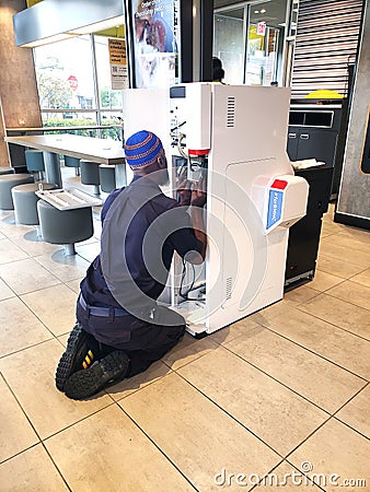An electrical engineer is setting up and debugging a new automatic service machine at a McDonald's restaurant Editorial Stock Photo