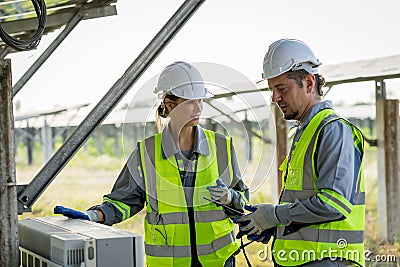 Electrical engineer on solar farm with large structure Check maintain rehearse damaged parts from use in order to produce Stock Photo