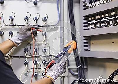 Electrical engineer tests the operation of the electric control cabinet on a regular basis for maintenance Stock Photo