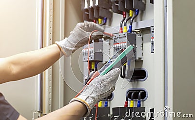 Electrical engineer tests the operation of the electric control cabinet on a regular basis for maintenance. Stock Photo