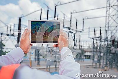 An electrical engineer uses a thermal meter to scan the structure and equipment of the power supply station to detect hot spots Stock Photo