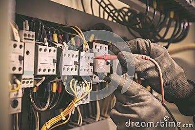 Electrical engineer using digital multi-meter measuring equipment to checking electric current voltage at circuit breaker Stock Photo