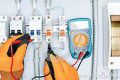 Electrical engineer using digital multi-meter to check current voltage Stock Photo