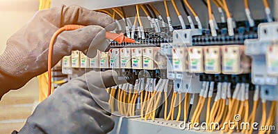 Electrical engineer using digital multi-meter to check current voltage at circuit breaker Stock Photo