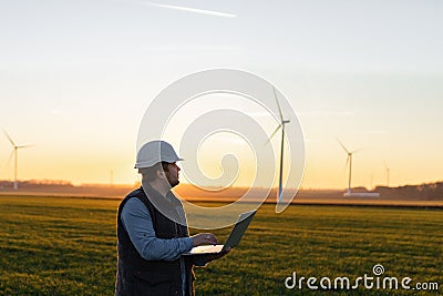 Electrical engineers working at wind turbine power generator station with laptop Stock Photo