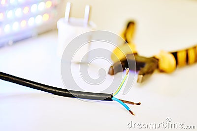 Three-core electric cable, metalwork pliers and LED lamp Stock Photo