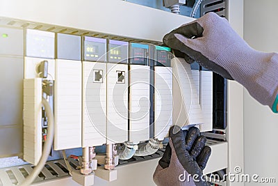 Electrical and Instrument technician replacing input and output card of programable logic controller PLC for oil and gas process Stock Photo