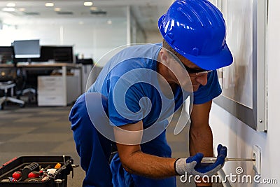 Electrical maintenance inspection.Tehnical maintenance worker checks the electricity in the office premises photo Stock Photo