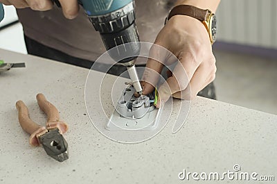 Electrical outlet repair. Hands of the master close-up Stock Photo