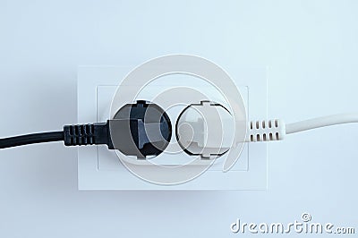 Electrical plugs from electrical appliances white and black are included in the socket on a white background. Stock Photo