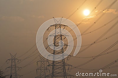 Electrical pylon and high voltage power lines near transformation station at Sunrise in Gurgaon Stock Photo