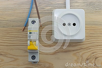 Electrical socket and automatic electrical switch on wooden background close up. Stock Photo