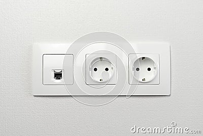 Electrical sockets on the wall with black connection internet plug and white wire. Socket set with usb cord and electricity cable Stock Photo