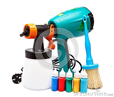 Electrical spray gun for coloration and a paintbrush and small bottles with color Stock Photo