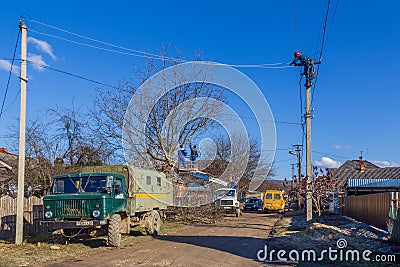 Electrical workers employees of Kubanenergo and rosseti cut tree branches and eliminate the breakage of the electric grid line Editorial Stock Photo