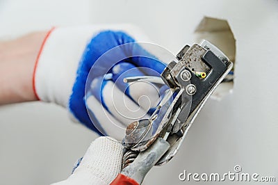 Electrican stripping insulation from wire. Stock Photo