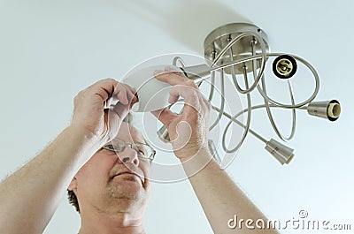 Electrician is attaching a plafond. Stock Photo