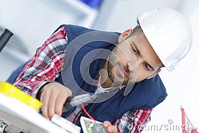 Electrician cutting red cable with cutters Stock Photo