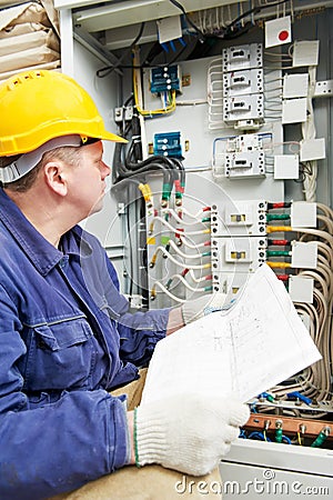 Electrician with drawing at power line box Stock Photo