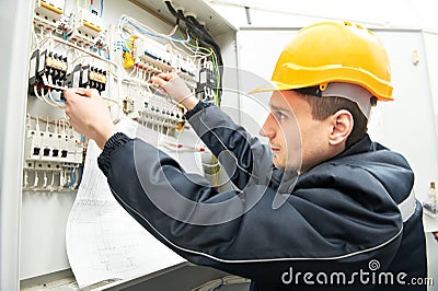 Electrician with drawing at power line box Stock Photo