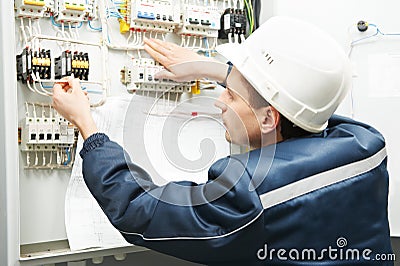 Electrician with drawing at power line box Stock Photo