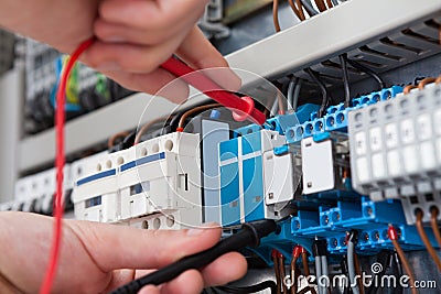 Electrician examining fusebox with multimeter probe Stock Photo