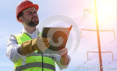 An electrician in the fields near the power transmission line. T Stock Photo