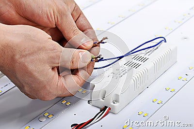 Electrician hands connect wires of led lamp Stock Photo